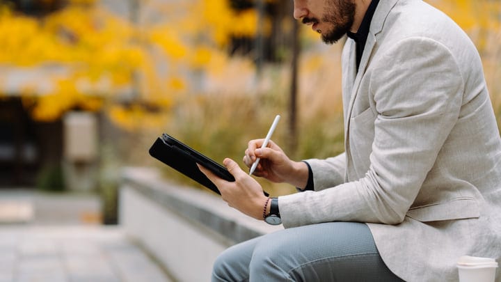 Focused Businessman Taking Notes In A City Park
