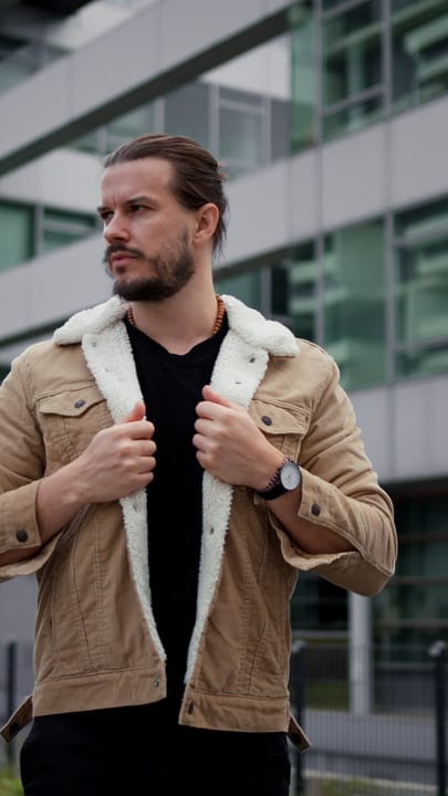 Confident Businessman Adjusts Jacket on Urban Walk