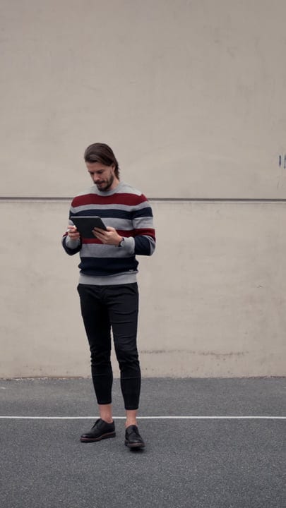 Businessman Engages With Tablet During City Walk