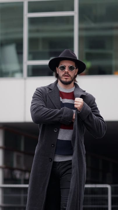 Confident Businessman Adjusts Coat During Urban Walk