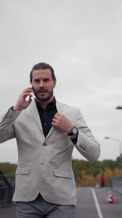 Confident Businessman Engages in Urban Stroll with Phone