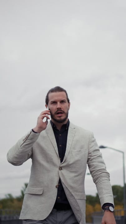Confident Businessman Navigates City Streets On Phone Call