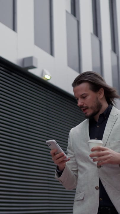 Businessman Walks Confidently With Coffee And Smartphone