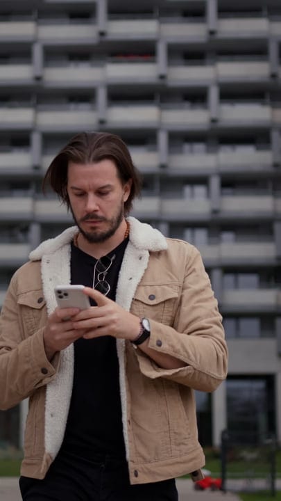 Focused Businessman Engaged With Smartphone In Urban Setting
