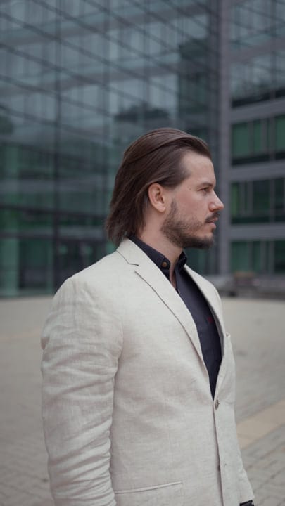 Confident Businessman Walking Amidst Glass Towers
